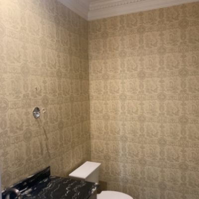 A bathroom with cream color wallpaper