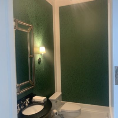 A bathroom with dark green wallpaper
