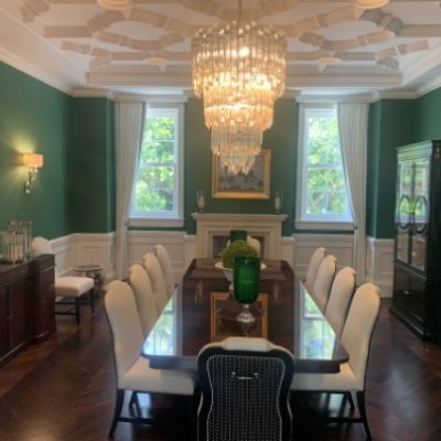 A dining room with green wallpaper